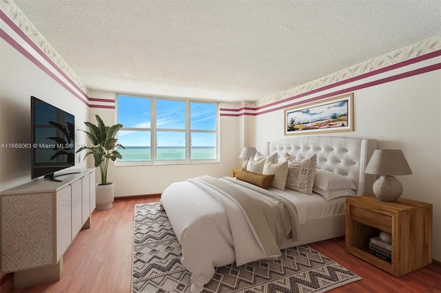 bedroom with light hardwood / wood-style flooring and a textured ceiling