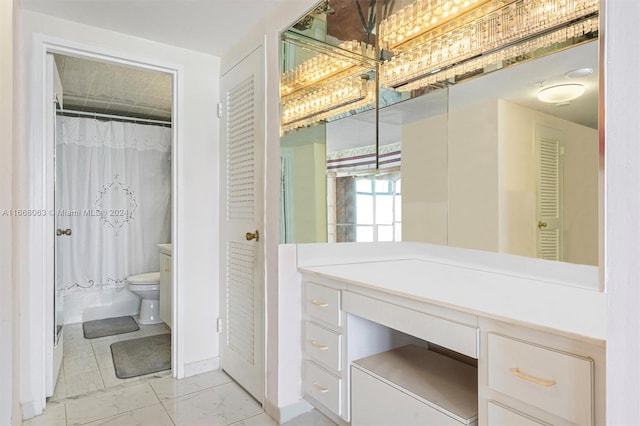 bathroom featuring curtained shower, vanity, and toilet