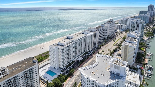 aerial view with a water view and a beach view