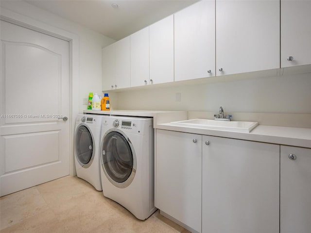 washroom featuring washer and clothes dryer, cabinets, and sink