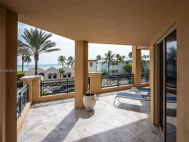 view of patio featuring a balcony and a water view