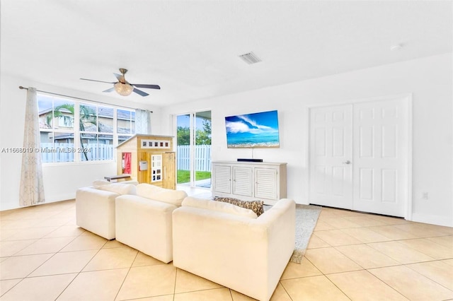 living room featuring a healthy amount of sunlight, ceiling fan, and light tile patterned floors