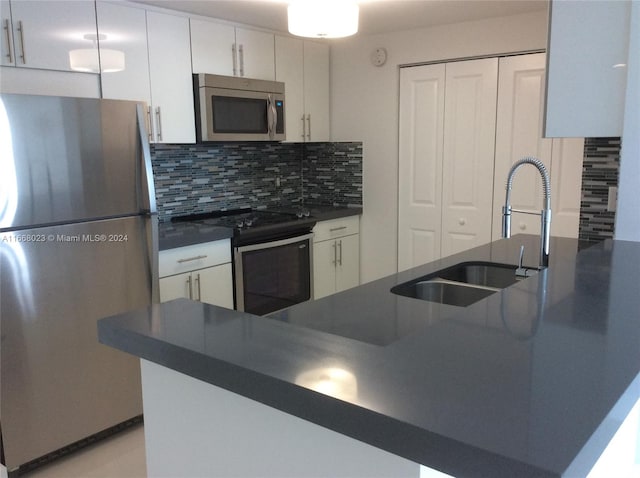 kitchen featuring white cabinets, backsplash, appliances with stainless steel finishes, and sink