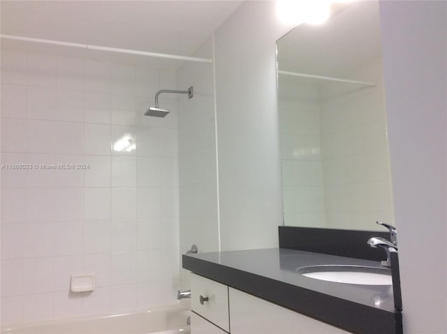 bathroom featuring tiled shower / bath combo and vanity