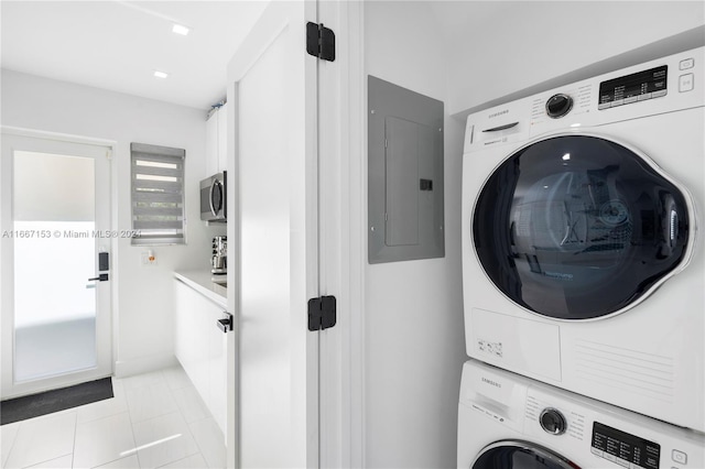 washroom with stacked washer / dryer, electric panel, and light tile patterned floors