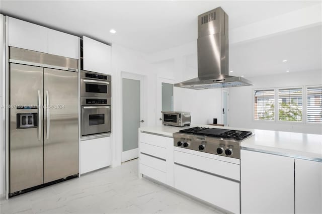 kitchen with wall chimney exhaust hood, white cabinets, and appliances with stainless steel finishes