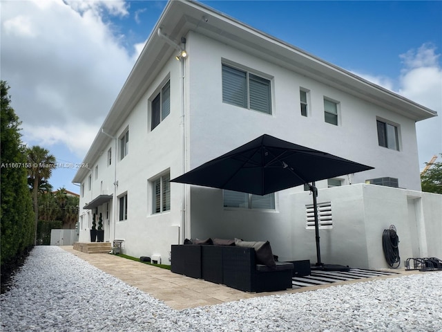 back of house featuring a patio and outdoor lounge area