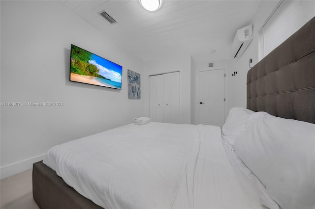 bedroom with a closet and a wall mounted air conditioner