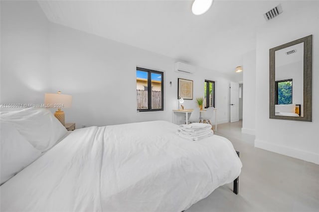 bedroom featuring multiple windows and a wall unit AC