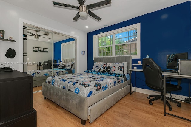 bedroom with a closet, light hardwood / wood-style floors, and ceiling fan