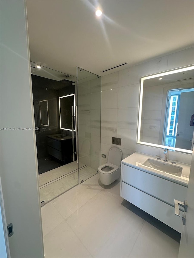 bathroom featuring a tile shower, tile walls, tile patterned flooring, vanity, and toilet