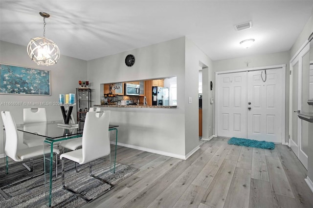 dining room featuring light hardwood / wood-style floors and a chandelier