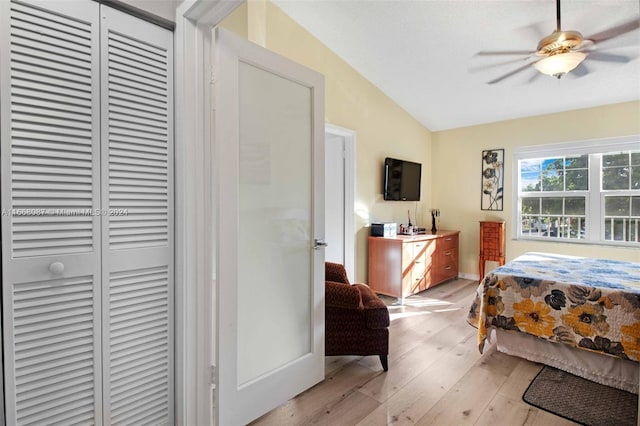 bedroom featuring light wood-type flooring, vaulted ceiling, and ceiling fan