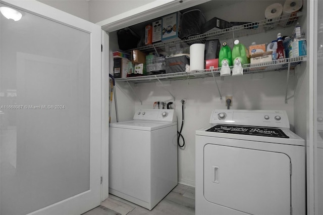 laundry room with light wood-type flooring and washing machine and dryer