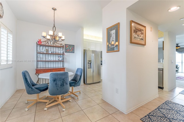 tiled dining area featuring ceiling fan with notable chandelier