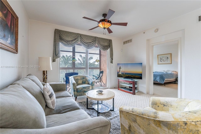 carpeted living room with ceiling fan