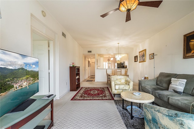 living room featuring ceiling fan with notable chandelier and carpet flooring