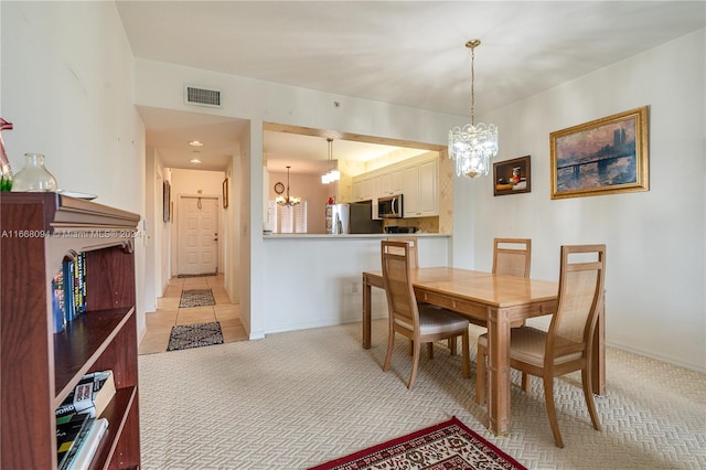 dining room with light colored carpet and a notable chandelier