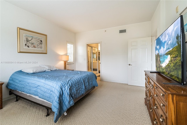 bedroom featuring light colored carpet and connected bathroom