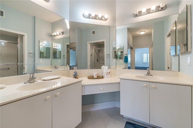 bathroom featuring tile patterned floors, an enclosed shower, and vanity