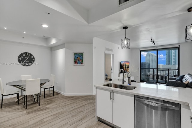 kitchen with white cabinets, pendant lighting, sink, and stainless steel dishwasher