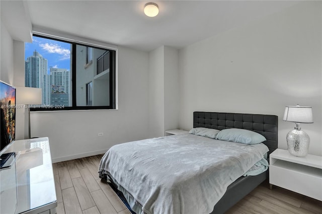 bedroom featuring floor to ceiling windows and light hardwood / wood-style flooring