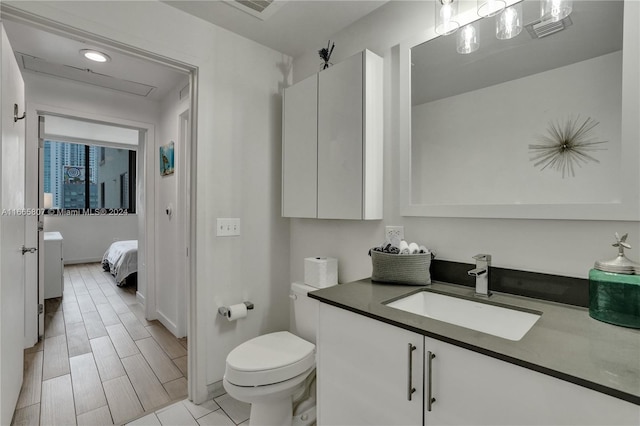 bathroom with hardwood / wood-style floors, vanity, and toilet