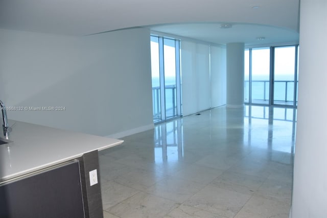 unfurnished room with a healthy amount of sunlight and floor to ceiling windows