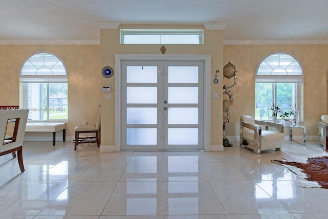 tiled foyer featuring ornamental molding, plenty of natural light, and french doors