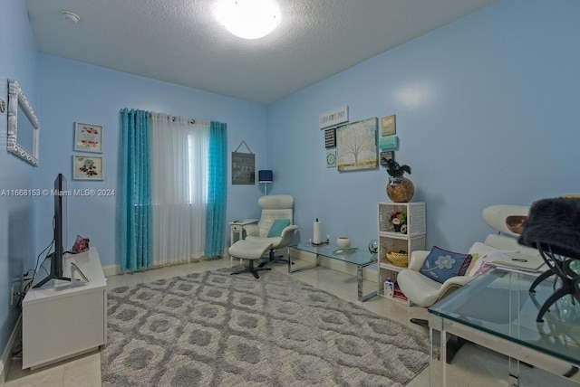 living area featuring a textured ceiling and light tile patterned floors