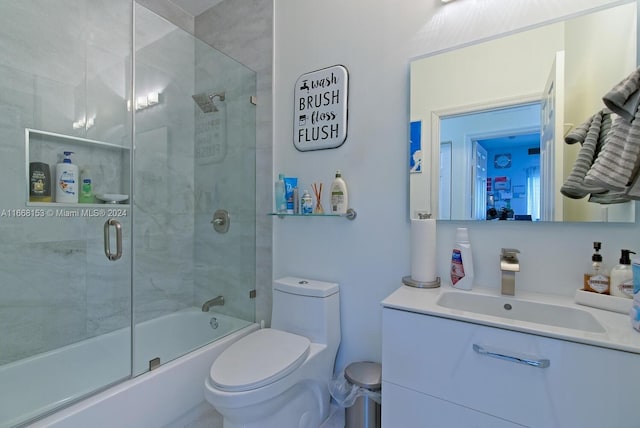 full bathroom featuring vanity, toilet, and combined bath / shower with glass door