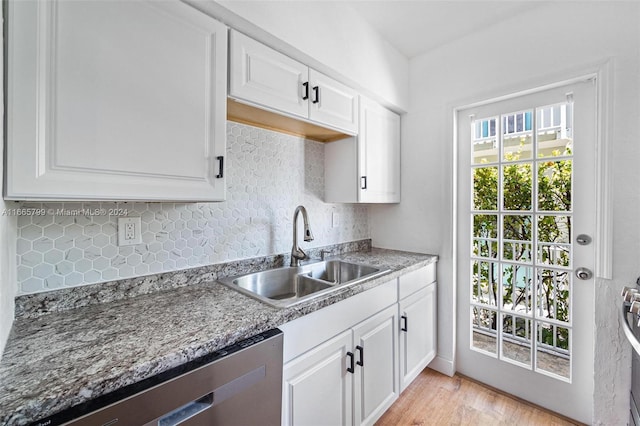 kitchen featuring white cabinets, dishwasher, sink, and light hardwood / wood-style floors