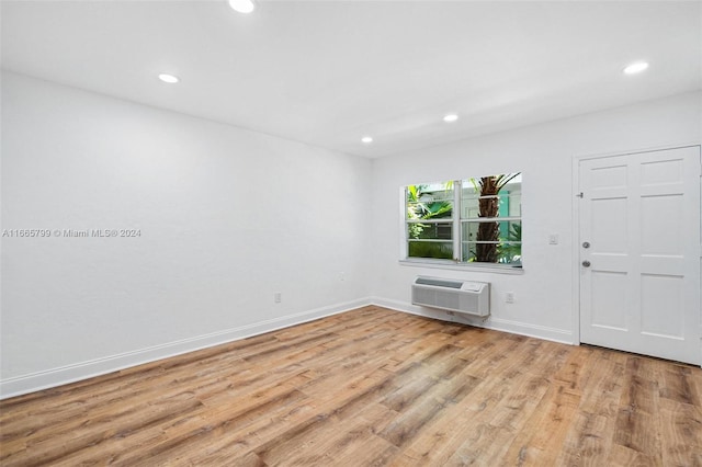 empty room featuring light hardwood / wood-style floors and a wall unit AC