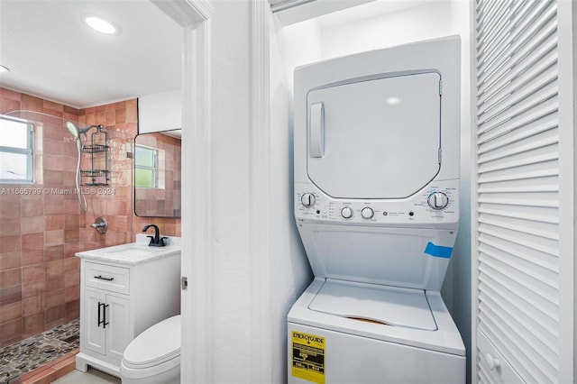 clothes washing area with stacked washer / drying machine and sink