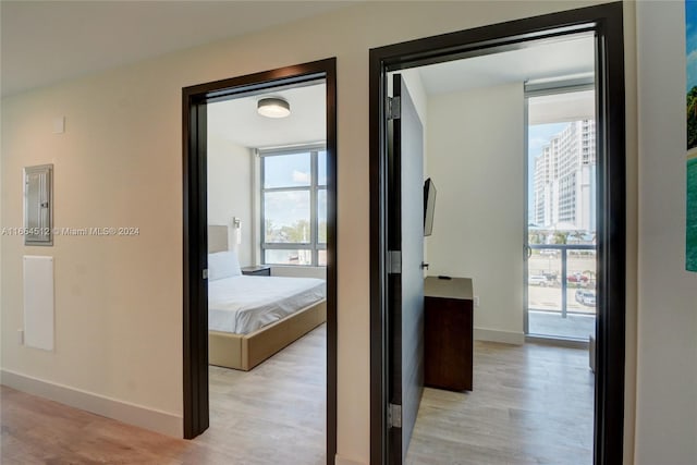 corridor featuring electric panel and light hardwood / wood-style floors