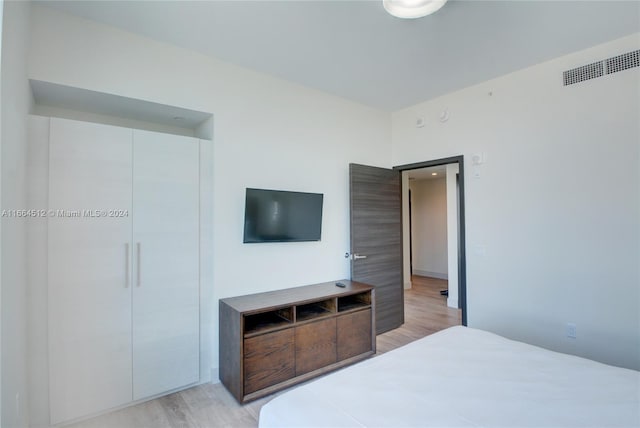 bedroom with light hardwood / wood-style flooring and a closet