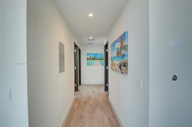 corridor featuring light hardwood / wood-style floors and electric panel