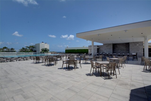 view of patio / terrace featuring a community pool and a water view