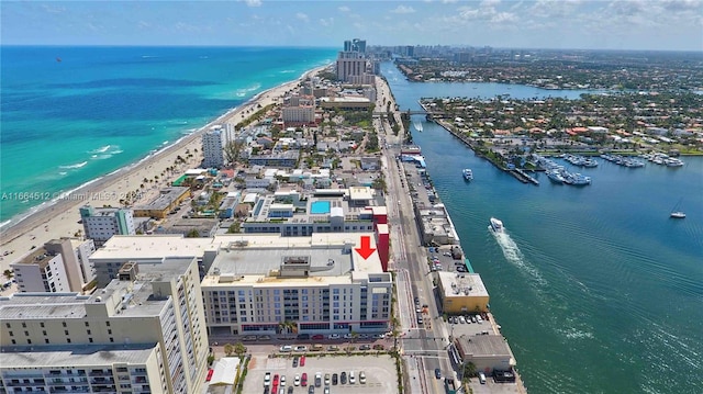 birds eye view of property featuring a water view and a beach view