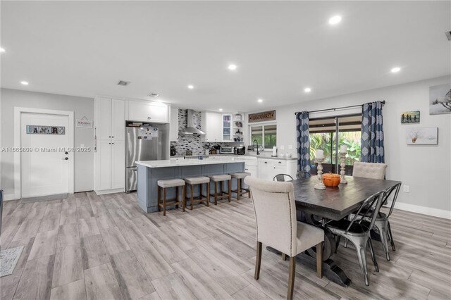 dining room featuring sink and light hardwood / wood-style flooring