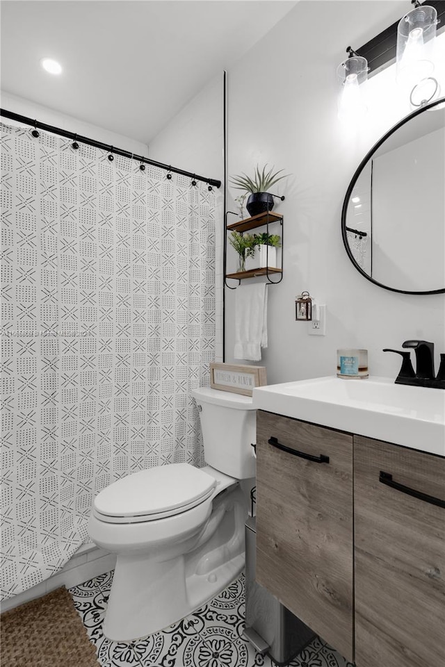 bathroom with toilet, vanity, and tile patterned floors