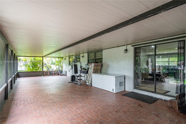 unfurnished sunroom with beamed ceiling