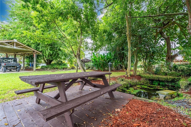 view of home's community with a wooden deck, a gazebo, and a lawn