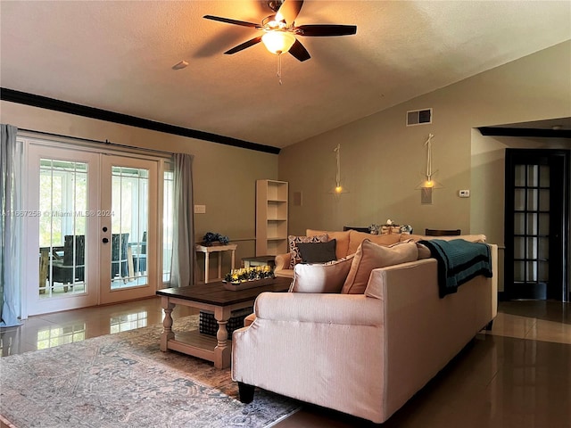 tiled living room featuring a textured ceiling, lofted ceiling, crown molding, ceiling fan, and french doors