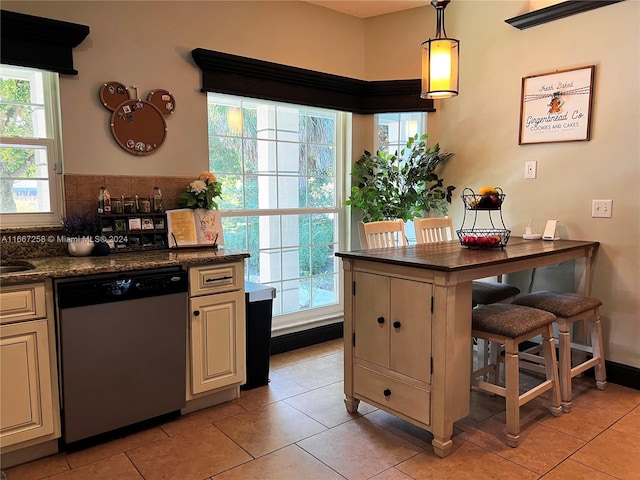 kitchen featuring dishwasher, light tile patterned floors, decorative light fixtures, and cream cabinetry