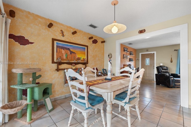 dining space with light hardwood / wood-style floors and a textured ceiling