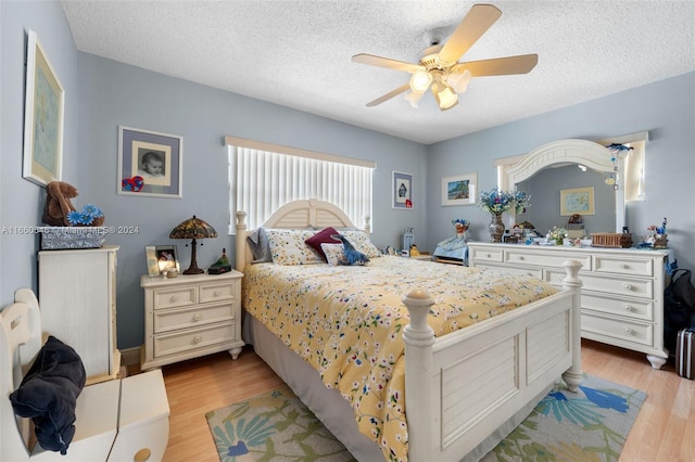 bedroom featuring light wood-type flooring, ceiling fan, and a textured ceiling