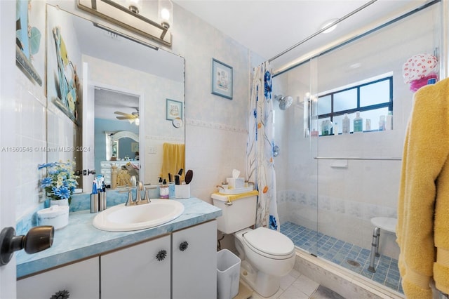 bathroom featuring ceiling fan, vanity, curtained shower, tile walls, and toilet