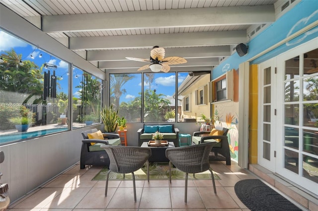 sunroom featuring beam ceiling and ceiling fan