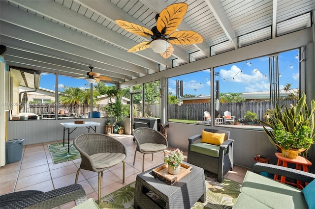 sunroom featuring ceiling fan, beamed ceiling, and a wealth of natural light